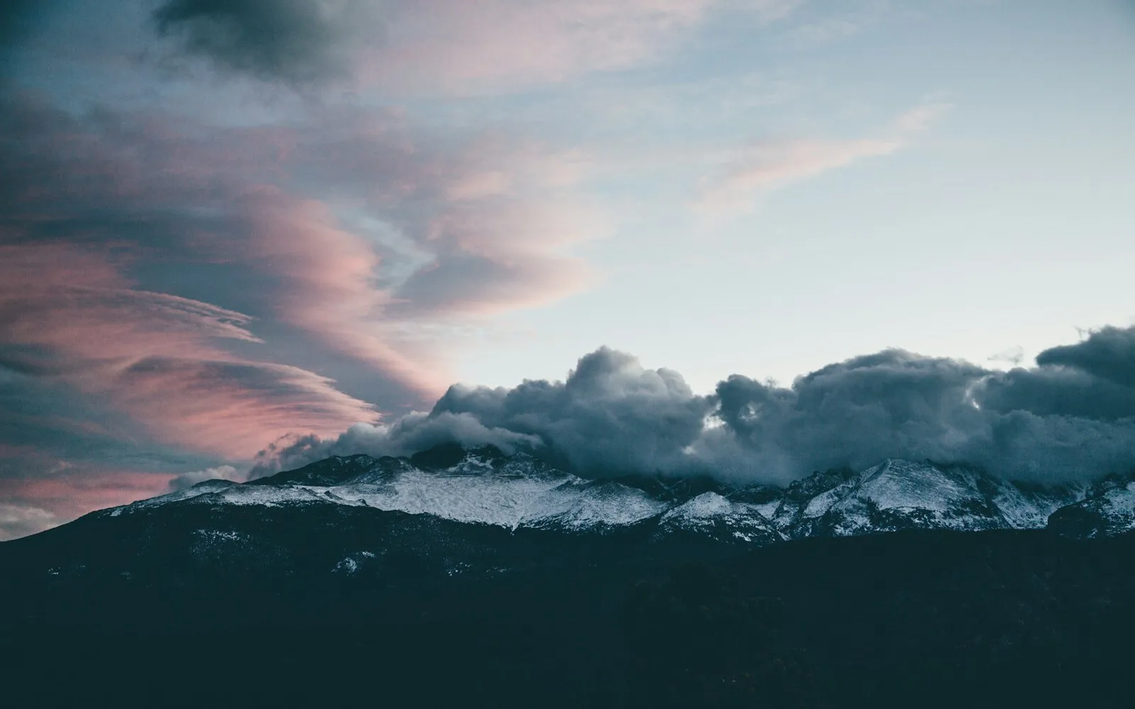 Snow-covered mountains disappearing into low clouds