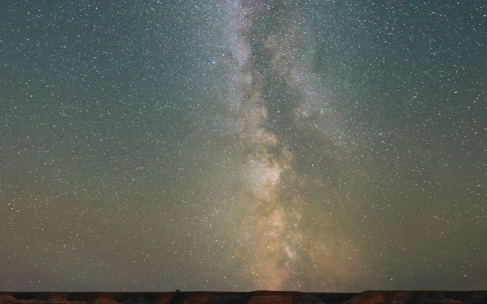 The Milky Way above a rugged desert landscape