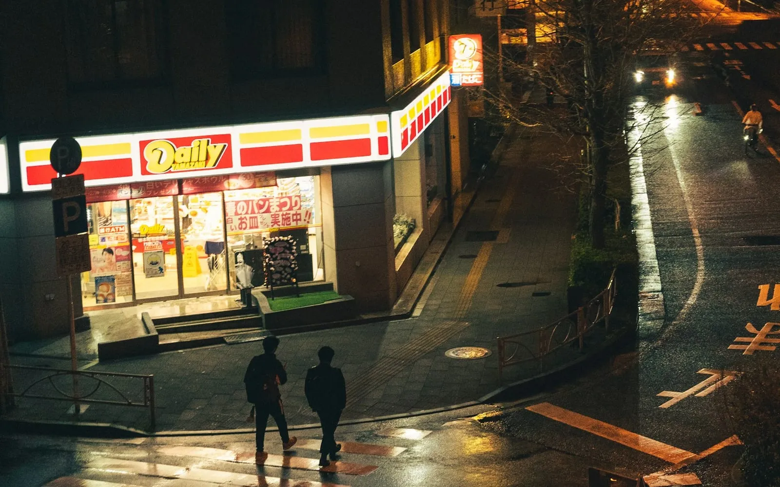 A convenience store glowing on a rainy night